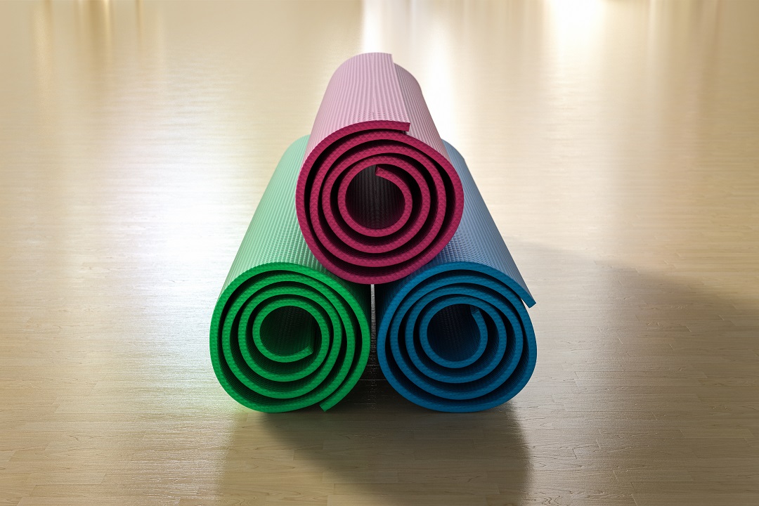 three rolled up yoga mats - pink green blue