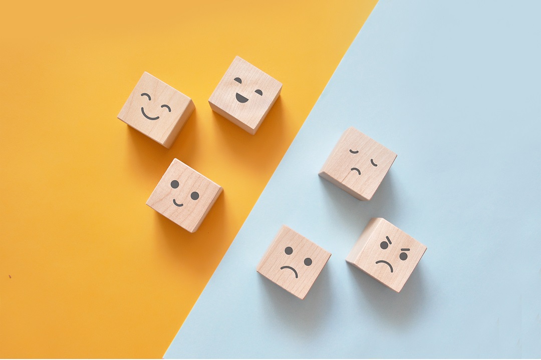 wooden blocks with emotion faces on gold and blue background