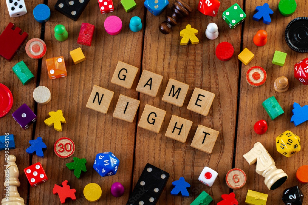 Image of game pieces and Game Night spelled out in wooden tiles