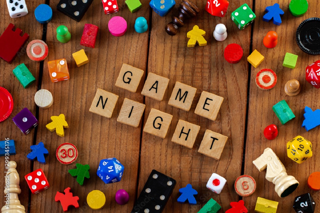 Game Night spelled out in wooden tiles, surrounded by other game pieces