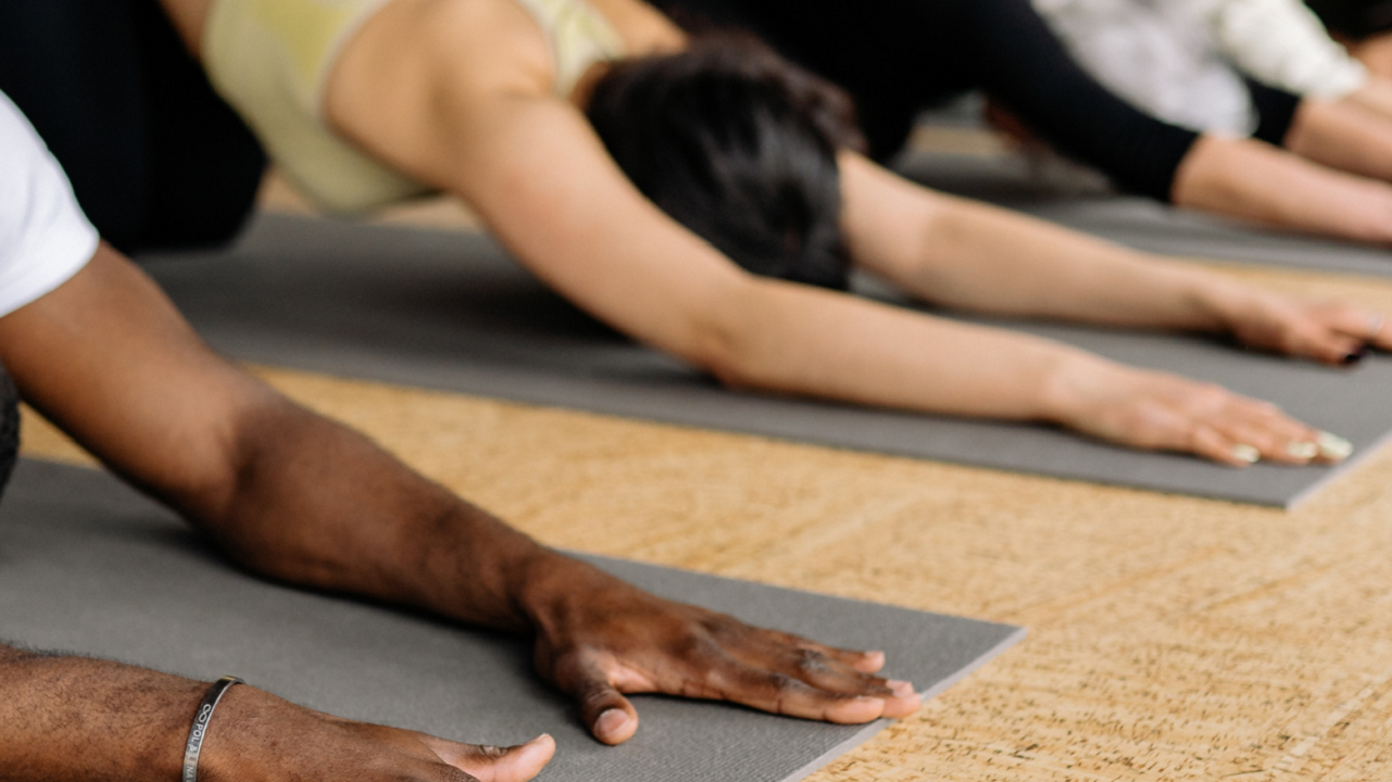 Image of two people in yoga pose (childs pose)