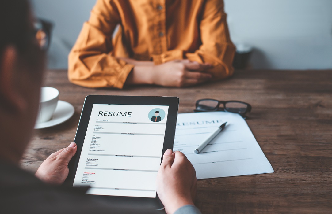 Image of person interviewing for a job, resume in hands of interviewer