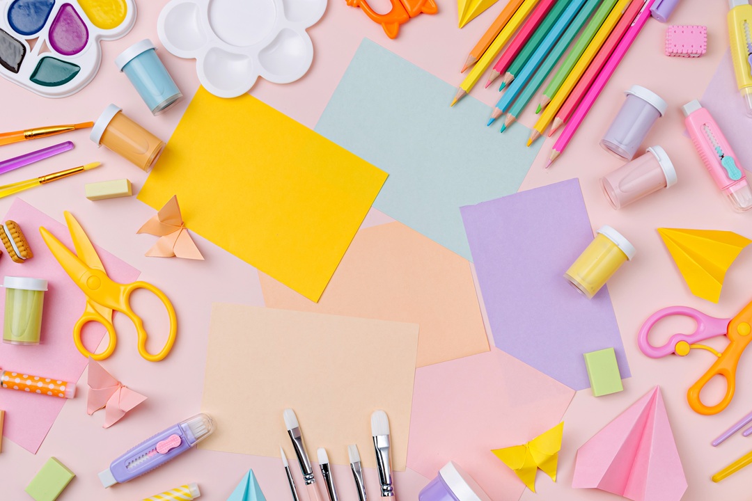 pastel colors of paper and art supplies on a table